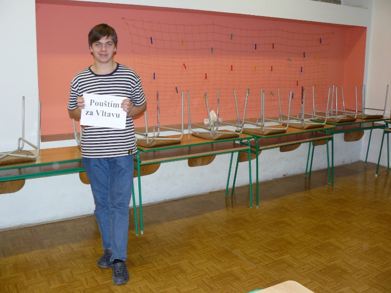 Student s cedulí s nápisem pouštím Vltavu